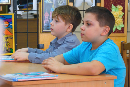 Chapaevsk, Samara region, Russia - Circa February, 2020: Two schoolboys sit at a Desk with booksのeditorial素材