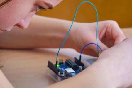 A girl in the classroom constructs an electronic deviceの写真素材