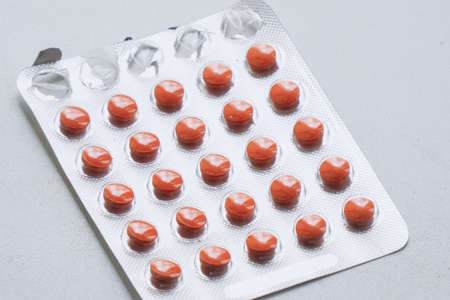 Blister with tablets on a gray background. Pharmaceutical or medical background