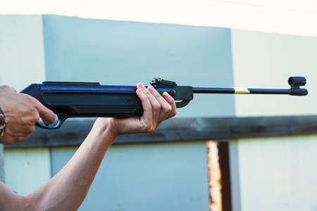 The man holds a rifle and takes aimの写真素材