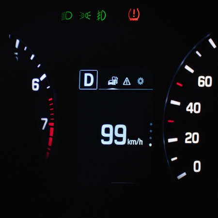 Speedometer in the car on the dashboard. The cars speedometer shows 99 mph