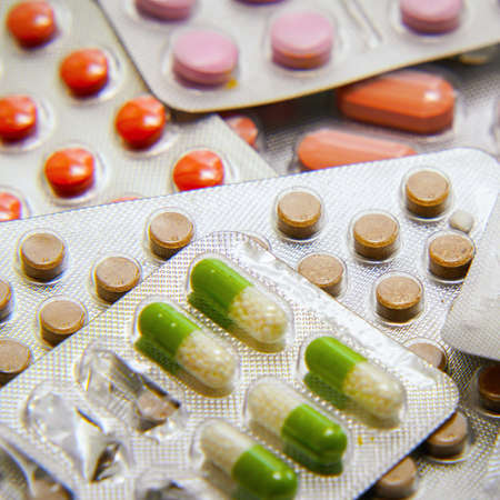 Different Colored tablets and capsules Packed in blisters. Pharmaceutical or medical background
