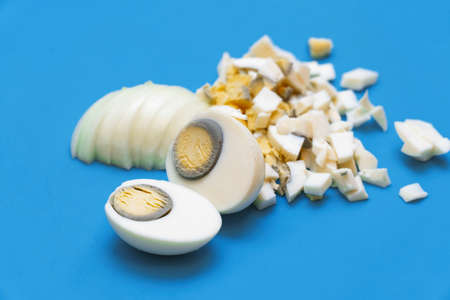 Boiled eggs cut or chopped into small pieces on a cutting Board