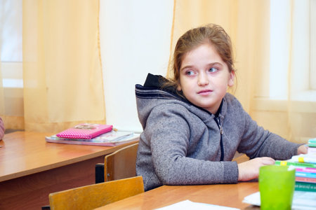 Chapaevsk, Samara region, Russia - December 24, 2020: Elementary school of the city of Chapaevsk. Portrait of a little schoolgirl girl at a school desk in the classroomのeditorial素材