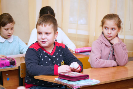 Chapaevsk, Samara region, Russia - December 24, 2020: Elementary school of the city of Chapaevsk. Little schoolgirl and schoolboy at the Desk in the classroomのeditorial素材