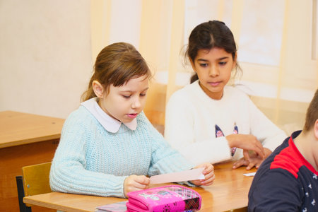 Chapaevsk, Samara region, Russia - December 24, 2020:Two girls in the classroom at the Desk listening to the teacherのeditorial素材