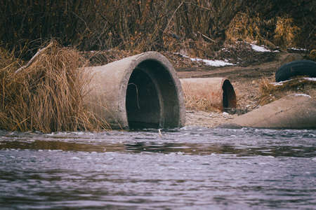 The water on the river flows from large pipes. Dam on riverの写真素材