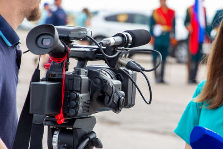 A videographer, Cameraman, or reporter reports from the street