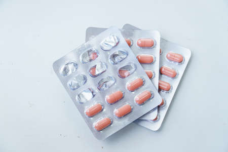 Tablets in a blister on white background. On top of the half-empty used blisterの写真素材