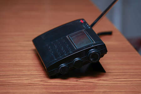 Black analog radio receiver on wooden tableの写真素材