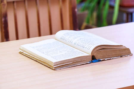 An open book on a wooden table. Selective focusの写真素材