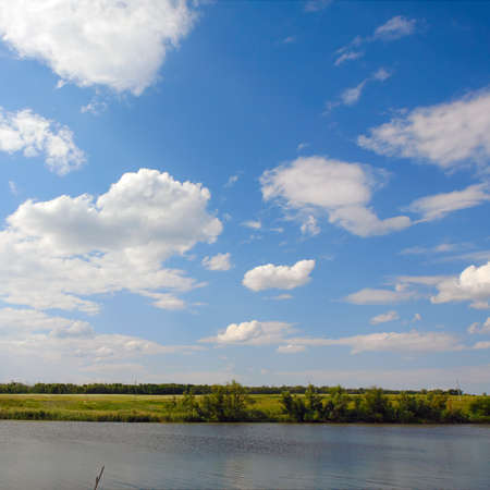 Landscape with clouds in blue sky over riverの写真素材
