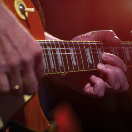 The guitarist plays on guitar. Hands of a Guitar player playing the guitar. Selective focus. Soft focusの写真素材