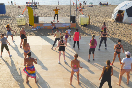 SAMARA, RUSSIA - JUNE 25, 2021: A group of girls are doing aerobics or dancing on the beach with a dance instructorのeditorial素材