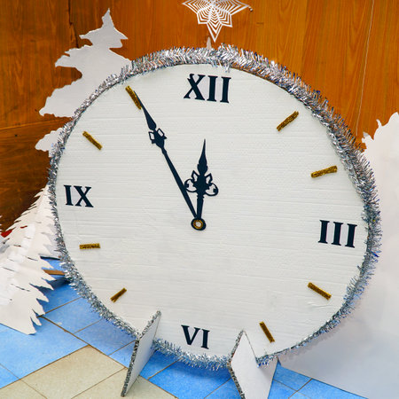 Homemade Christmas clock made of paper or cardboard. Its five minutes to twelve on the clockの写真素材
