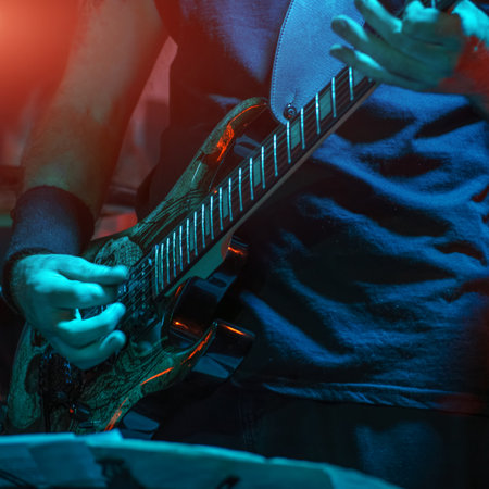 The guitarist plays on guitar. Hands of a Guitar player playing the guitar. Selective focus. Soft focusの写真素材