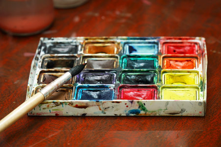 Watercolor paints and a brush on the table. Selective focusの写真素材