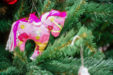 A homemade rag horse on a Christmas tree. Christmas toys on the Christmas tree. Selective focusの写真素材
