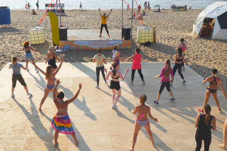 SAMARA, RUSSIA - JUNE 25, 2021: A group of girls are doing aerobics or dancing on the beach with a dance instructorのeditorial素材