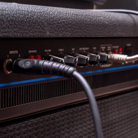 Plug jack with cable plugged into a black guitar combo amplifierの写真素材