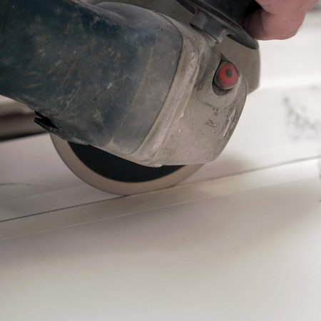 A construction worker saws ceramic tiles using an angle grinderの写真素材