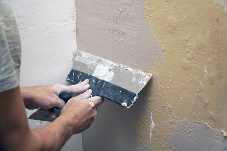A man plastering a wall with a spatula. Apartment renovationの写真素材
