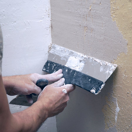 A man plastering a wall with a spatula. Apartment renovationの写真素材