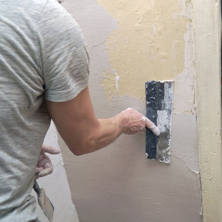 A man plastering a wall with a spatula. Apartment renovationの写真素材