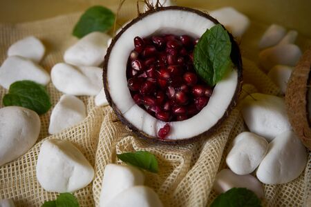 A proposal to serve a pomegranate fruit in a coconut. Health and vitamins, great colors, the way fruit is served.の写真素材