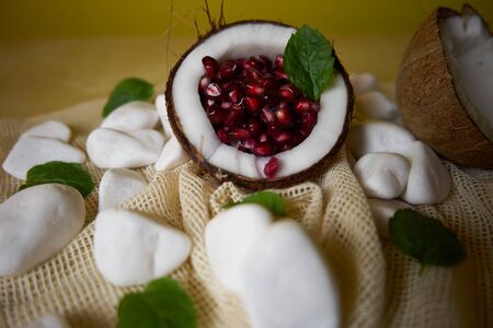 A proposal to serve a pomegranate fruit in a coconut. Health and vitamins, great colors, the way fruit is served.の写真素材