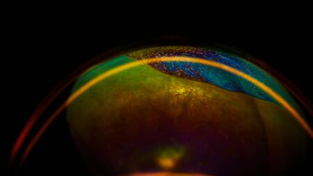 Soap bubble on dark background. Lots of colors and magical texture was created thanks to strong lighting.の写真素材