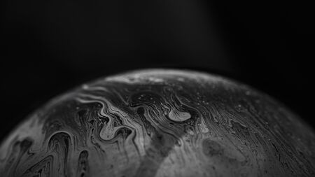 Soap bubble on dark background. Lots of colors and magical texture was created thanks to strong lighting.の写真素材