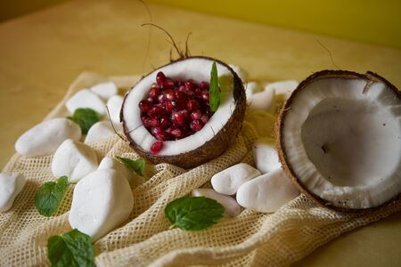 A proposal to serve a pomegranate fruit in a coconut. Health and vitamins, great colors, the way fruit is served.の写真素材