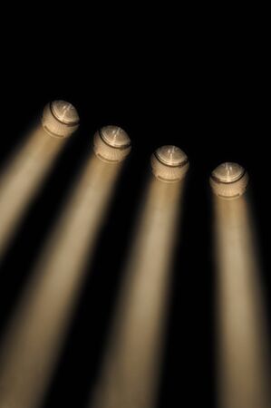 Four beams of light on black background