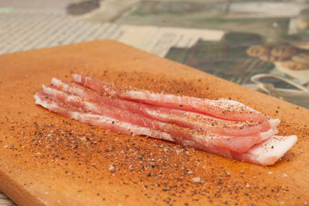 baked slices of bacon on a dark wooden background.の写真素材