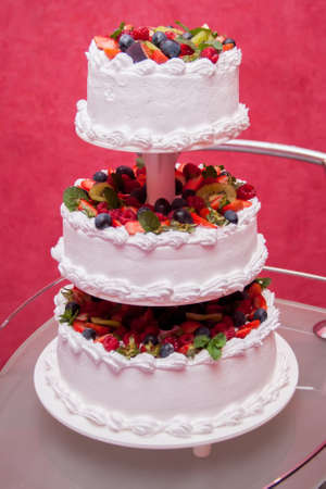 Wedding cake decorated with flowers and berriesの写真素材