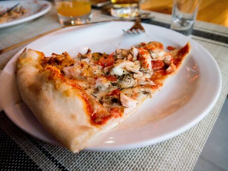 Pizza with seafood, mozzarella, mussels, octopus, squid, salmon, shrimp on an isolated white backgroundの写真素材