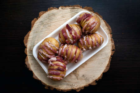 Raw potatoes with bacon at the wooden cutting boardの写真素材