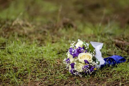 Bride is holding a wedding bouquet and a glass of champagneの写真素材