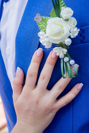 Close-up of bride's hand on the groom chestの写真素材