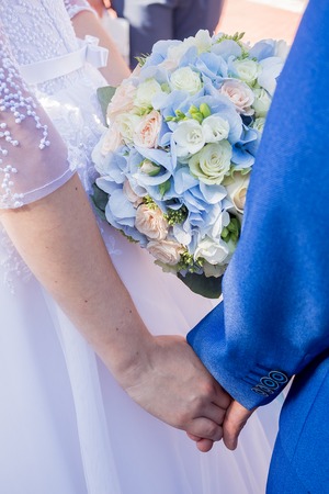 Close-up of groom's hand holding bride's handの写真素材