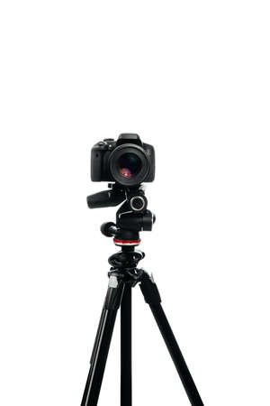 Photo camera with lens on the tripod front view. Studio shot on white backgroundの写真素材