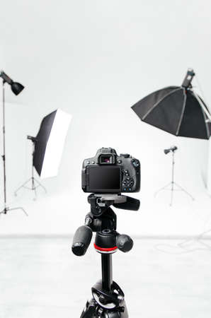 Empty photo studio with lighting equipment and camera