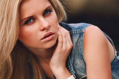 Outdoor portrait of young sensual woman in the hood closeup.