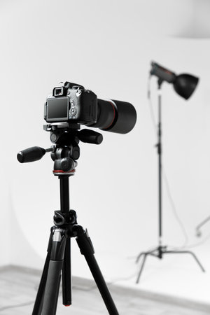 Photo camera with macro lens on the tripod side view. Studio shotの写真素材