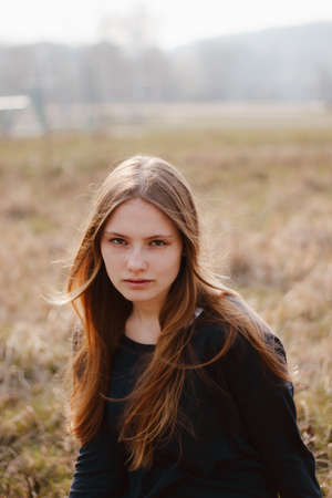 Stylish portrait of young girl outside windy. Cute female model. girl outdoor spring portraitの写真素材