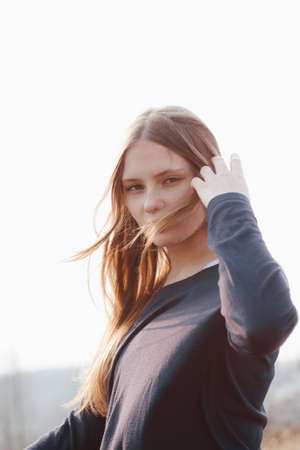 Stylish portrait of young girl outside windy. Cute female model. girl outdoor spring portraitの写真素材