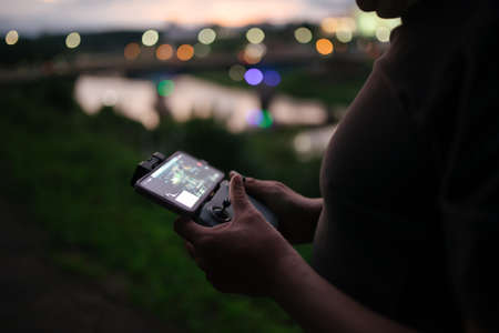 Man operating a drone using a remote controller close-up.の写真素材