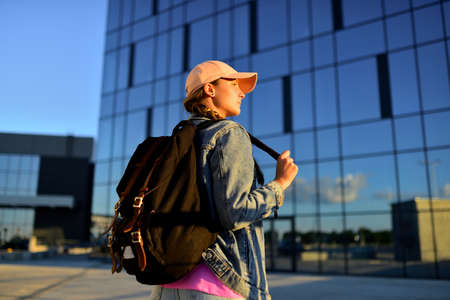 Travelling tourist with her backpack in walking down in downtown, Adventure and travel in the concept . Backpack rear view. Tourism in city.の写真素材
