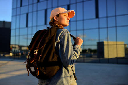 Travelling tourist with her backpack in walking down in downtown, Adventure and travel in the concept . Backpack rear view. Tourism in city.の写真素材